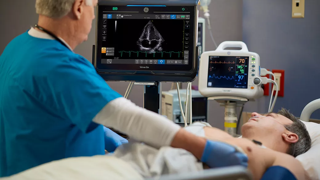 Doctor working on a patient looking at a Venue Go monitor