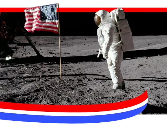 A photograph of an astronaut placing the American flag on the moon with a red, white, and blue border.