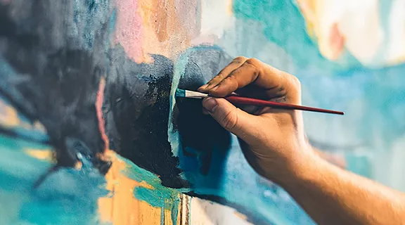 Hands of Young painter working on his art inside his studio.