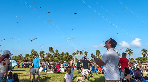 A big crowd of people flying their kites in the air