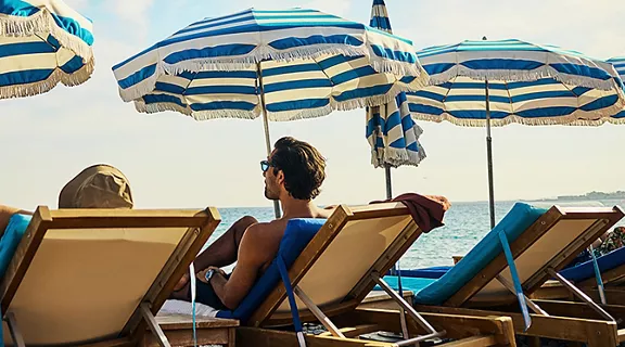 Young adult couple headed to the beach on holiday at a luxury hotel on the Côte d'Azur in South France.