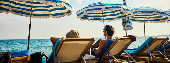 Young adult couple headed to the beach on holiday at a luxury hotel on the Côte d'Azur in South France.