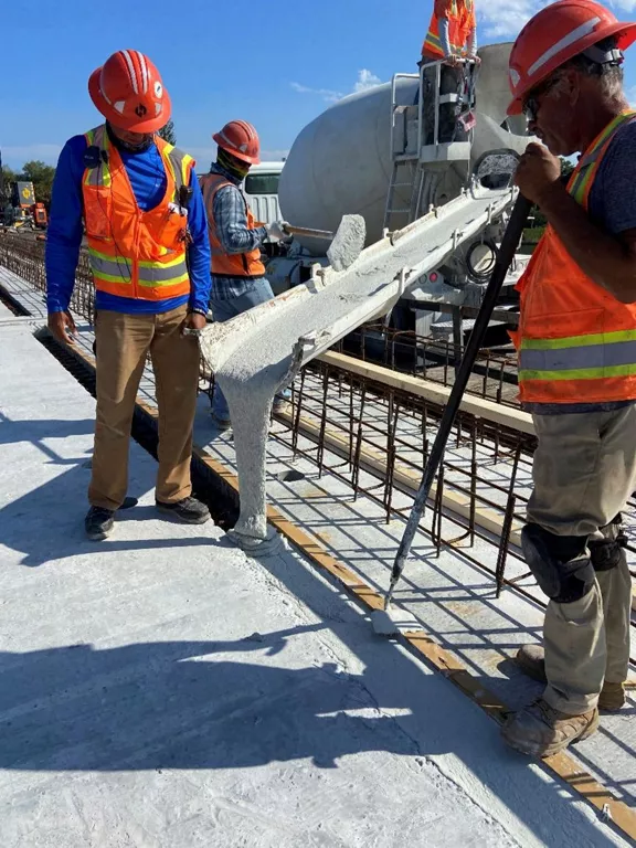 Construction workers pouring Ultra High Performance Concrete for Brightline West