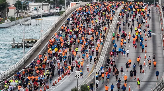 A large group of runners and walkers going across the bridge