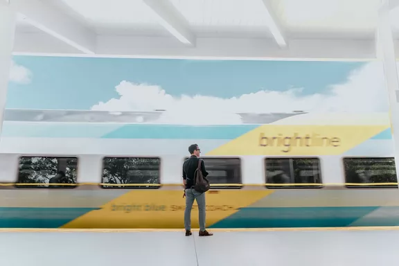 Guest awaits on the platform as a train arrives