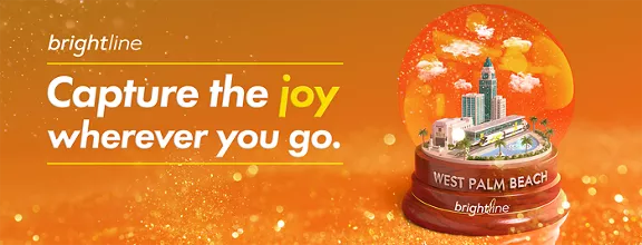 A West Palm Beach snow globe featuring a Brightline train on an orange, glittery holiday background.