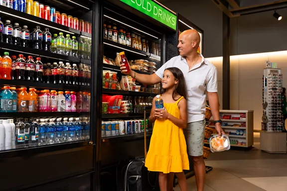 A father shopping with his daughter at a Brightline station MRKT store.