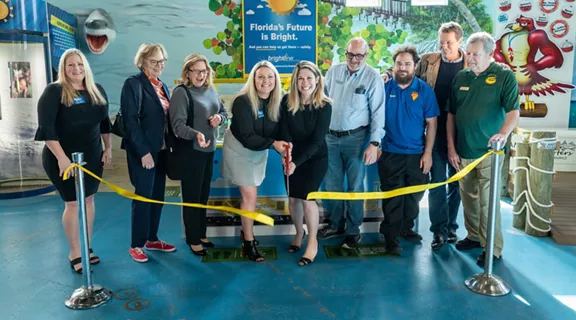 Brightline and The Children's Museum team cutting a yellow ribbon for the new Brightline Trains safety exhibit