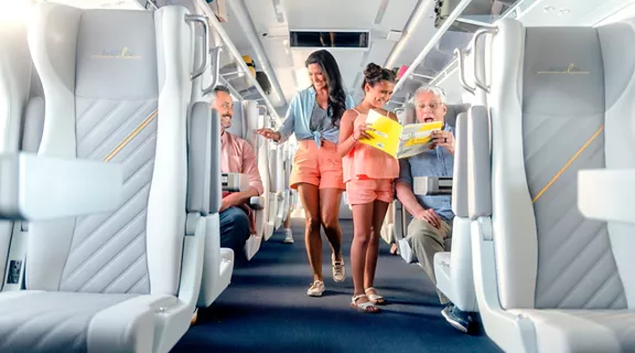 A family standing in the aisle while traveling aboard a Brightline train