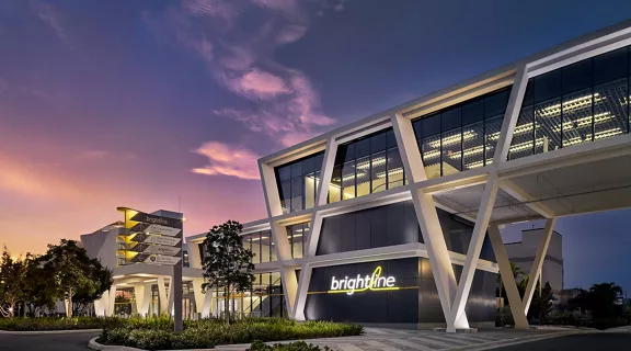 A Brightline shuttle with the Miami skyline in the background.