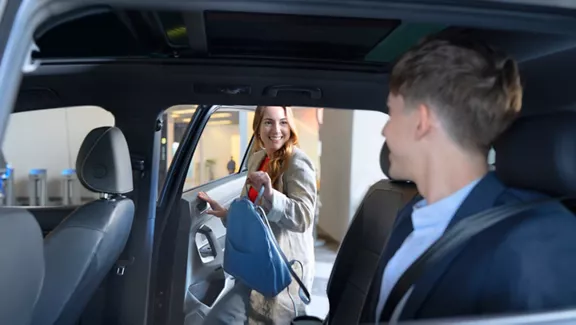 A guest steps into a vehicle as another party awaits