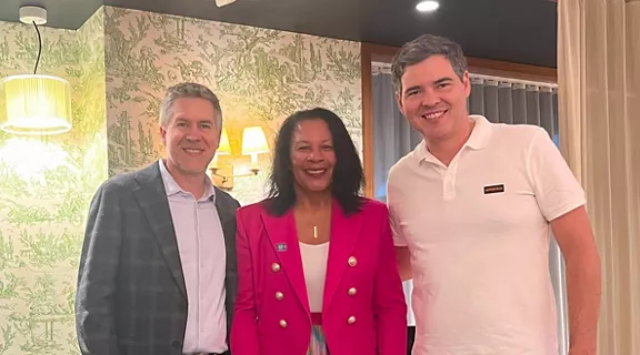 Brightline and Inter & Co representatives posing on a small stage at a conference.