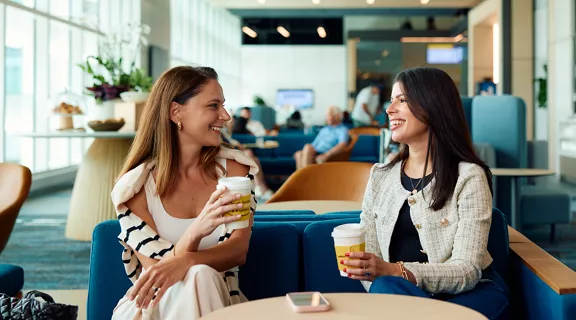 Two women talking over coffee in Brightline premium lounge