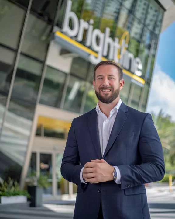 Brightline Florida's President Patrick Goddard standing in front of a Brightline station