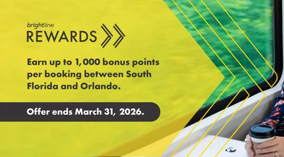 A woman enjoying a hot cup of coffee while taking a ride on a Brightline train.