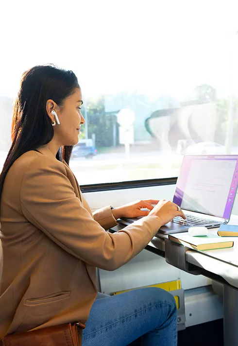 Student working on computer while on train.