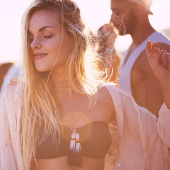 Blonde woman dancing outside with a sunlight hue around