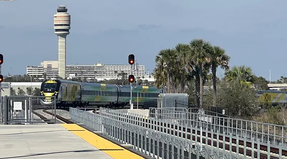 Brightline train approaching the Brightline Orlando Station platform near the MCO airport