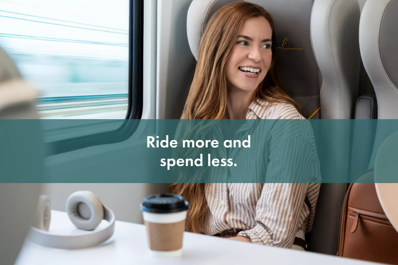 A woman smiling while riding on a Brightline train.
