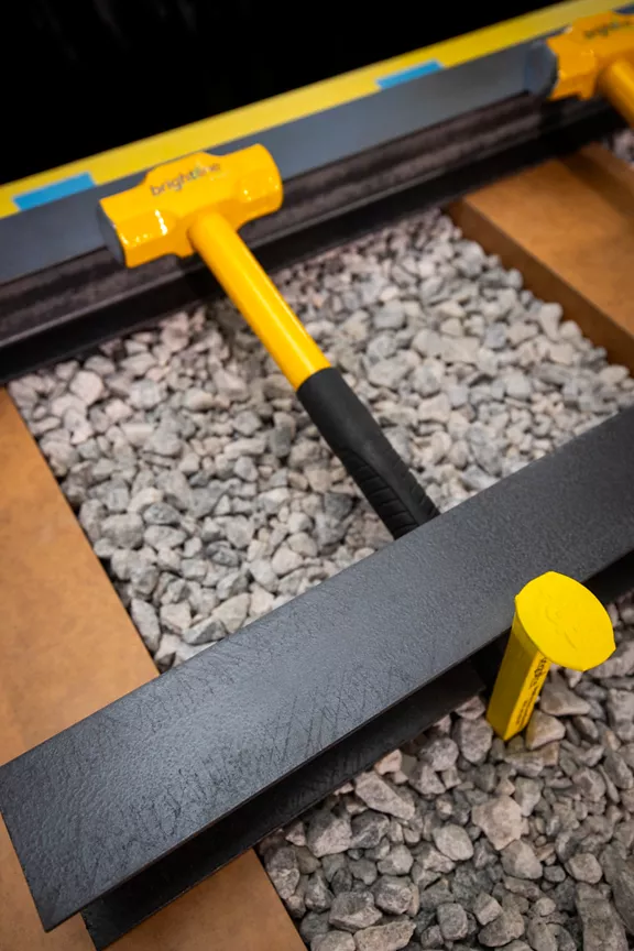 A yellow hammer and spike in a sample railroad model