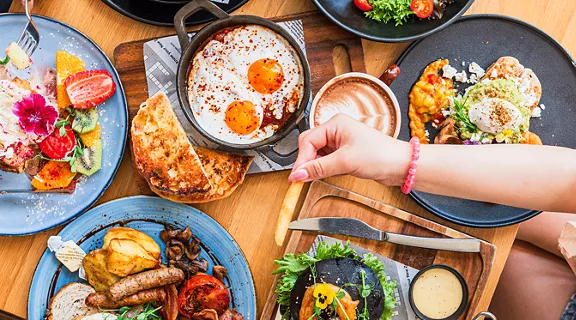 A couple eating a table full of food at a brunch