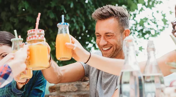 Group of friends having a break in the countryside together drinking juices
