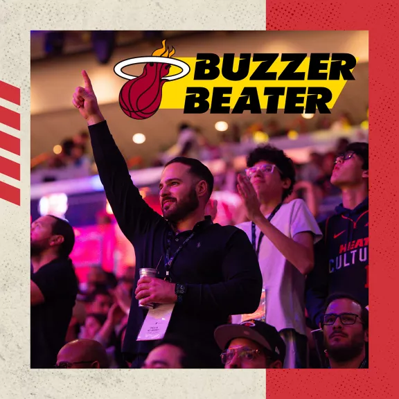 Basketball fans cheering in the stands with a Buzzer Beater logo placed above them