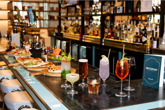 Drinks and food assortments lay across a bar
