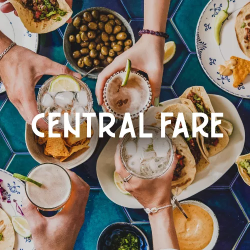 Central Fare words over table with lots of food on plates.
