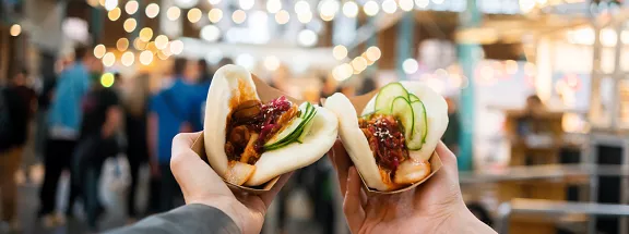 Two people holding food from the festival
