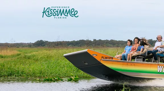 Guests on Wild Florida airboat moving through the Everglades with an Experience Kissimmee Florida overlay.