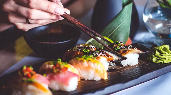 A person eating a variety of sushi 