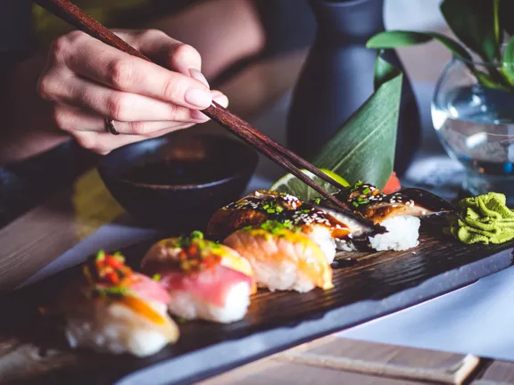 A person eating a variety of sushi 