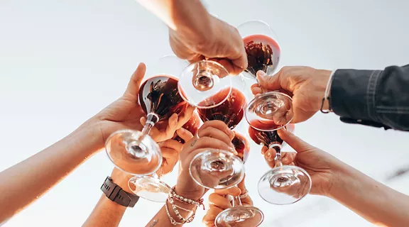 7 arms holding glasses toasting