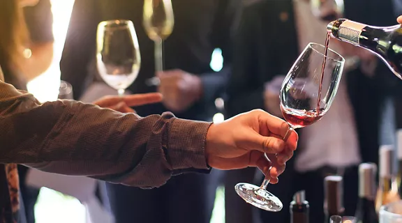 Someone pouring wine in a wine tasting event