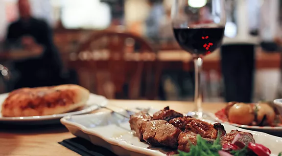 A photo of skewers and a glass of wine