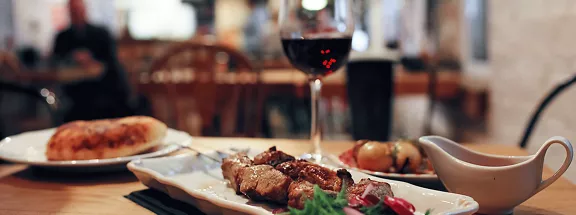 A photo of skewers and a glass of wine