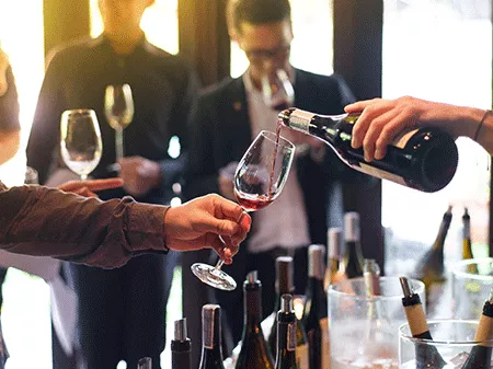 Someone pouring wine in a wine tasting event