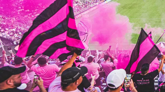 Soccer fans in stadium dressed in pink and black