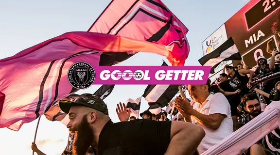 Fans at soccer game cheering in the stadium.