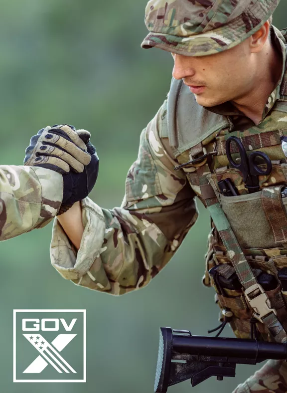 Two uniformed servicemen shaking hands, with a GOVX logo in the corner.