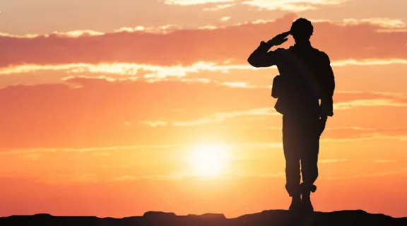 A silhouette of a soldier saluting before a sunset sky overlayed with the words GOVX and Brightline