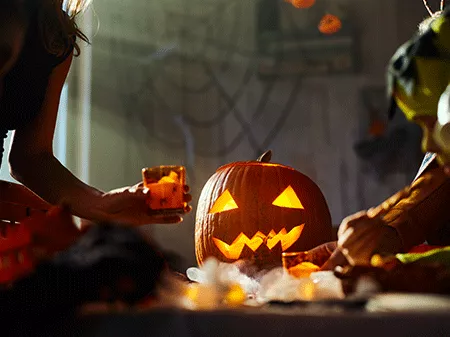 A group of people decorating the pumpkin