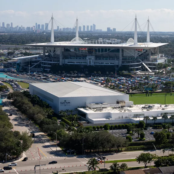 A large modern sports stadium dominates the scene, viewed from an elevated vantage point.