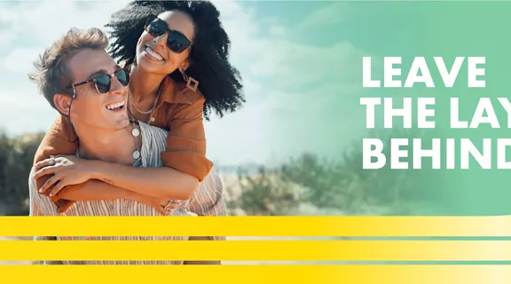 couple with sunglasses smiling with words Leave the layers behind above a image of a train