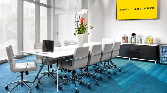 Two women talking over coffee in Brightline premium lounge