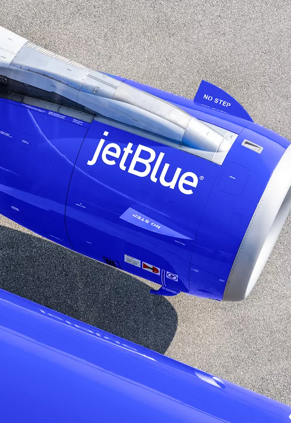 A photo of an engine on a JetBlue plane.