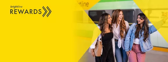 Three woman taking a selfie with a Brightline train car in the background
