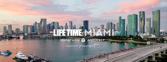 Miami Marathon participants running downtown with the skyline in the background.