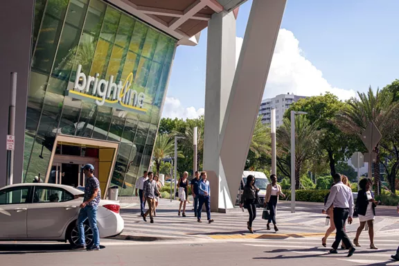 Exterior of Brightline's MiamiCentral station with people walking to and from the building